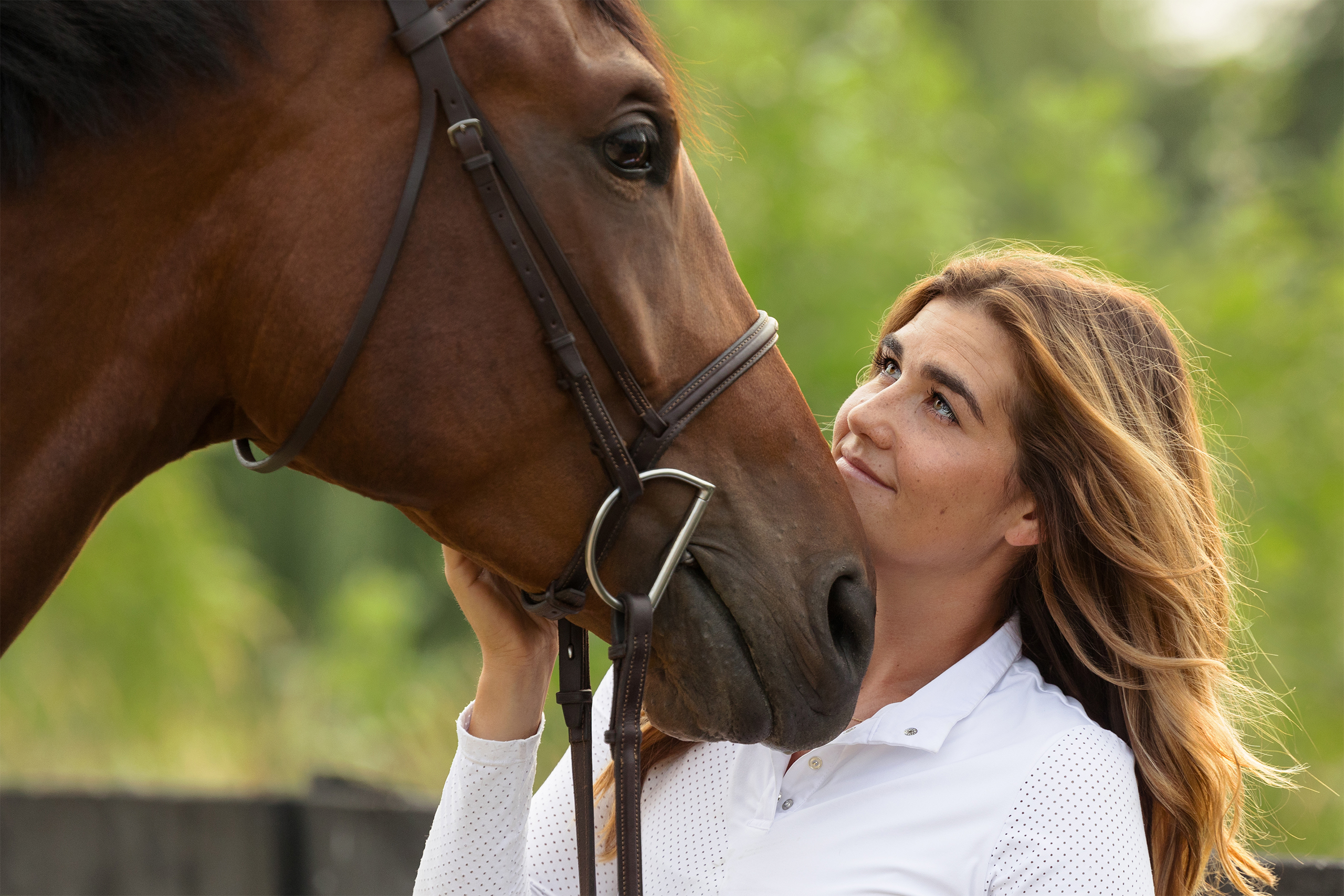 woman gazing lovingly into the eyes of her horse